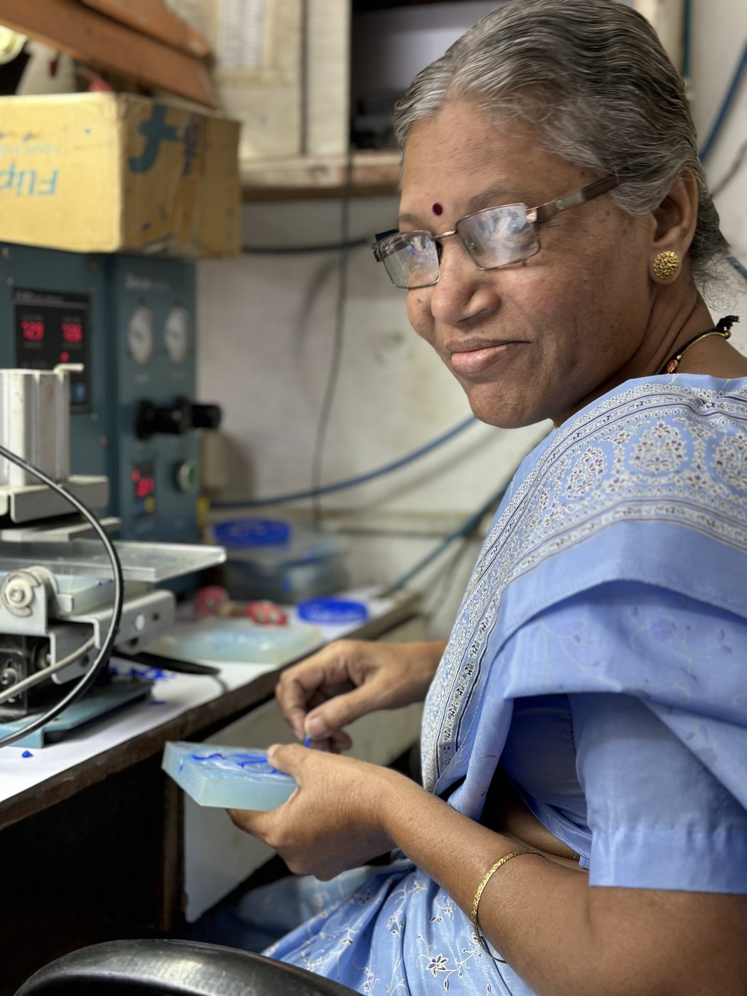 DVNJEWELRY artisan shaping a wax jewelry model at her workbench in the Mumbai atelier